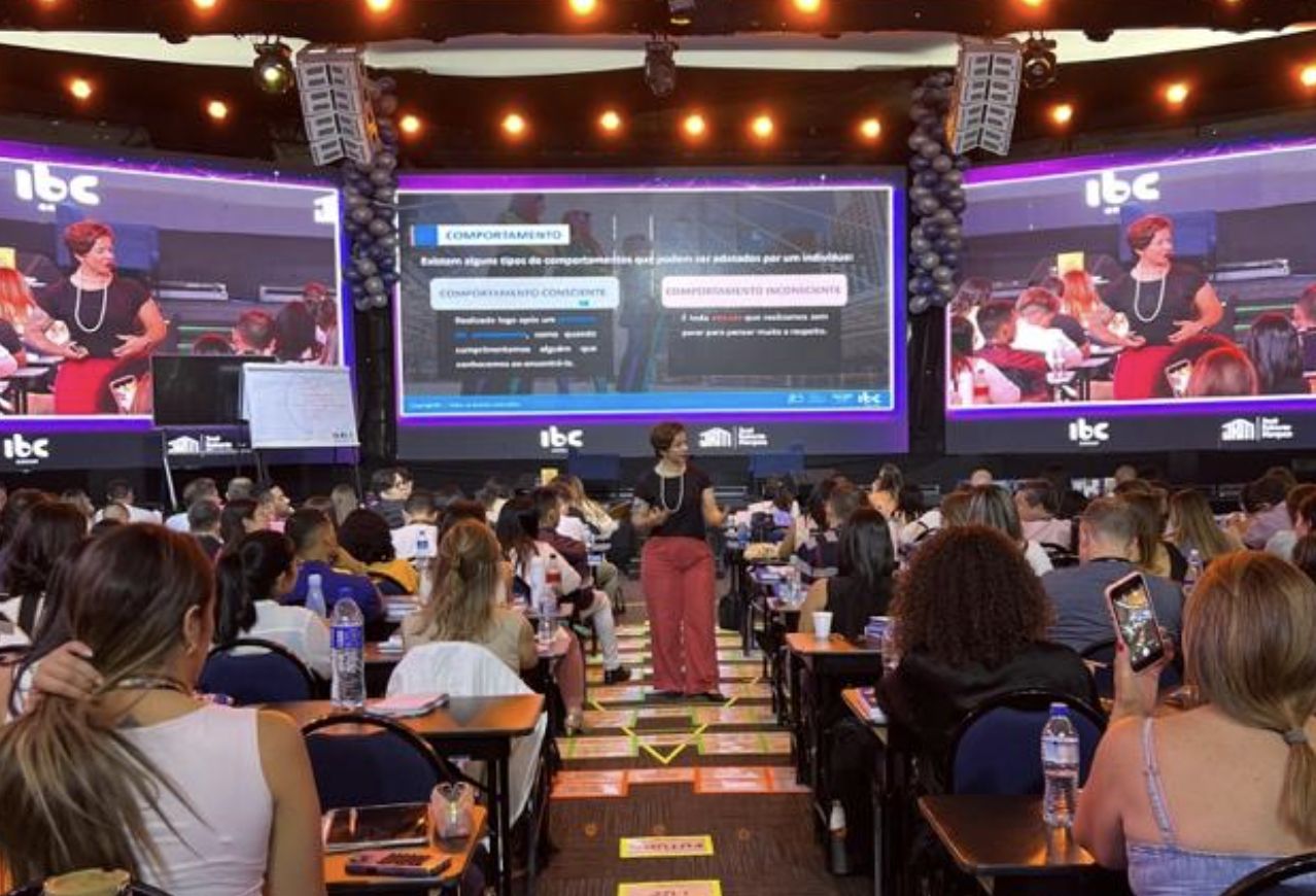 Andreza conduzindo treinamento presencial em grande evento